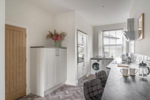 a white kitchen with a sink and a counter at Tudor House-Windermere Centre in Windermere