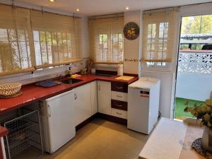 a kitchen with white cabinets and a red counter top at "COZY LOFT", TERRACE, PARKING and SWIMMING POOL in Málaga