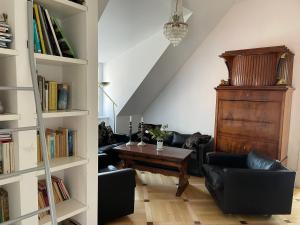 een woonkamer met een tafel en een boekenplank bij Villa Sonnenburg in Bad Schandau