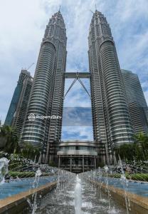 two tall buildings with a fountain in front of a city at City Home Suites Kuala Lumpur City Centre in Kuala Lumpur