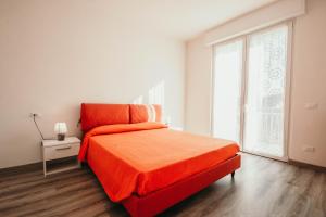um quarto com uma cama laranja e uma grande janela em AL 13 Rosso - Lakeside Leisure & Business em Stresa