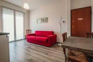 - un salon avec un canapé rouge et une table dans l'établissement AL 13 Rosso - Lakeside Leisure & Business, à Stresa