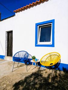 two chairs and a table in front of a building at Cozy 3 BR Home - Close to Beach in Lourinhã