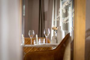 Love Room Bohème Les Petits Plaisirs في أنجيه: طاولة مع كؤوس النبيذ و مزهرية