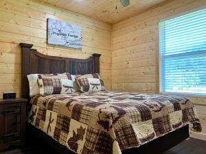 a bedroom with a bed in a log cabin at The Brick House: Brand NEW! 3 Bedroom Home with private driveway in Pigeon Forge