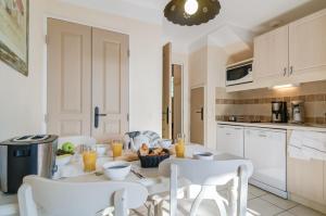 uma cozinha com uma mesa e cadeiras numa cozinha em Village Pierre & Vacances Le Rouret em Grospierres
