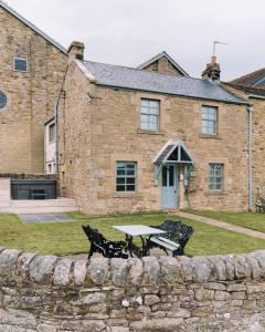 uma mesa e dois bancos em frente a um edifício em Derwent Manor Boutique Hotel em Consett