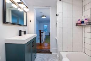 a bathroom with a sink and a tub at The Orchard, a family friendly home- hot tub, fire pit, yard games in Luray +39 photos