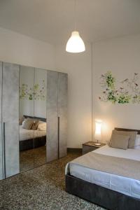 1 dormitorio con 2 camas y espejo en Homelink Firenze - Charlotte en Florencia