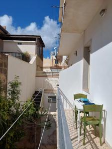 un balcone con tavolo e sedie su un edificio di Casa Palma a 100 passi dal mare a Marina di Ragusa