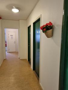 a hallway with a basket of flowers on the wall at Torget Vandrarhem in Kävlinge