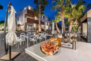 a table with a pizza and drinks on a patio at [Lusso e relax] con piscina a 2 minuti dal mare in Miami Platja