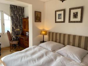 een slaapkamer met een bed, een bureau en een raam bij Villa Sonnenburg in Bad Schandau
