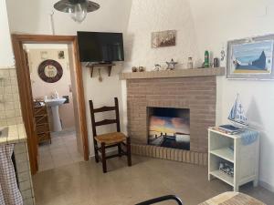 a living room with a fireplace and a television at Casa Vacanza Sa dommu de Teresa in Nebida