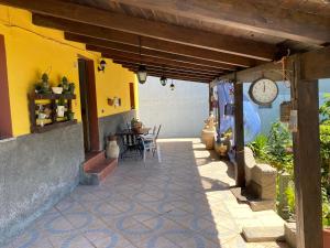 a patio with a clock on the side of a house at Casa Vacanza Sa dommu de Teresa in Nebida