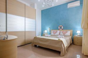 a blue bedroom with a bed and a sink at Affaccio Sul Mare Luxury Home in Porto Cesareo