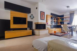 a living room with a bed and a tv and a kitchen at Affaccio Sul Mare Luxury Home in Porto Cesareo