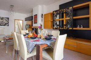 a dining room with a table and white chairs at Affaccio Sul Mare Luxury Home in Porto Cesareo