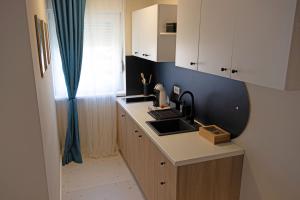 a small kitchen with a sink and a window at JAZZ 2 apartman in Brčko +5 photos