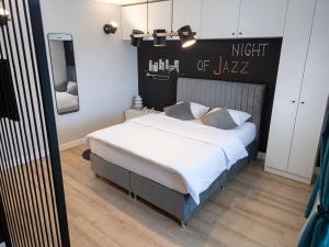 a bedroom with a bed with a night sign on the wall at JAZZ 2 apartman in Brčko