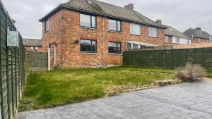 a brick house with a yard in front of it at Fully Serviced Three Bed House in Durham in Durham