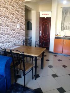 a table and chairs in a room with a stone wall at Mombasa Shanzu One Bedroom Apartment /Swimming Pool/Free WiFi in Mombasa