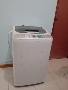 a white trash can sitting on the floor in a room at Homestay Ainul in Pendang