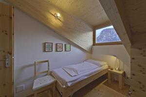 Chesa Piz Chalchagn - Pontresina في بونتريسنا: غرفة نوم صغيرة بها سرير ونافذة