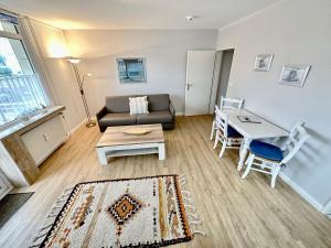 ein Wohnzimmer mit einem Sofa und einem Tisch in der Unterkunft Appartement 36 in Westerland