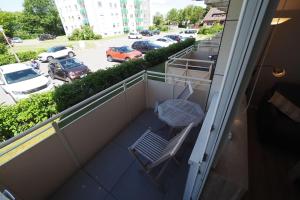 einen Balkon mit einer Bank und einem Parkplatz in der Unterkunft Appartement 36 in Westerland