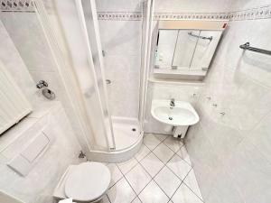 ein weißes Bad mit einem WC und einem Waschbecken in der Unterkunft Appartement 36 in Westerland