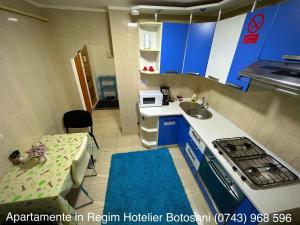 a room with a kitchen with a sink and a table at Apartament Uvertura Mall/Lidl cu parcare gratuita in Botoşani