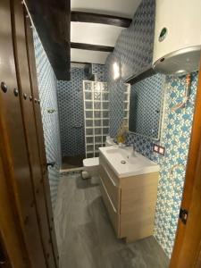 La salle de bains est pourvue d'un lavabo, de toilettes et de carrelage bleu. dans l'établissement La carchata 1, à Siete Aguas