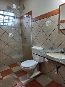 a bathroom with a toilet and a shower and a sink at Pousada Mundo Dha Lua in Sao Jorge