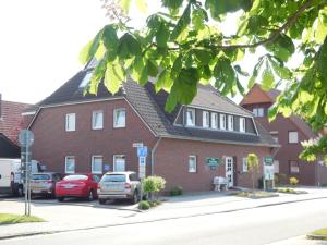 a red brick building with cars parked in front of it at Wohnung Typ A im Haus Friedeburg EG, Carolinensiel in Carolinensiel