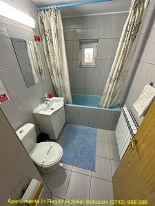 a bathroom with a toilet and a sink and a tub at Apartament Uvertura Mall/Lidl cu parcare gratuita in Botoşani