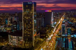 een skyline van de stad 's nachts met een hoog gebouw bij The Westin Lima Hotel & Convention Center in Lima