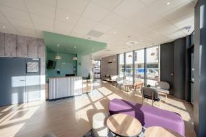 un vestíbulo de oficina con sillas y mesas púrpuras en B&B HOTEL Toulon Centre Gare, en Toulon