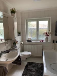 łazienka z toaletą, umywalką i wanną w obiekcie Ferienhaus Bendestorf, Waldweg 38,Nähe Hamburg w mieście Bendestorf