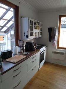 a kitchen with white cabinets and a stove top oven at Nedre Kjellerstuvei, Oslo House Second floor in Lillestrøm