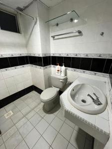 uma casa de banho branca com um WC e um lavatório em Glory Beach Resort em Porto Dickson