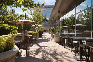 an outdoor patio with tables and chairs and umbrellas at The Westin Reston Heights in Reston
