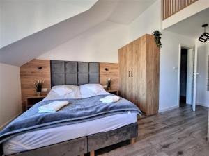 sypialnia z dużym łóżkiem z drewnianym zagłówkiem w obiekcie Willa Sky w Jastrzębiej Górze