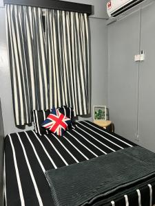 um quarto com uma cama com riscas pretas e brancas em Glory Beach Resort em Porto Dickson