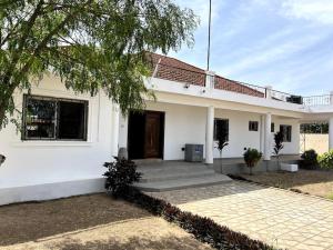 Biały dom z drzwiami i drzewem w obiekcie Laffie House w mieście Sukuta
