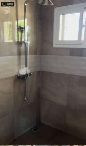 baño con cabina de ducha y ventana en Laffie House, en Sukuta