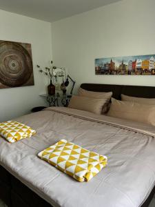 a large bed with two yellow and white pillows on it at Ferienwohnung am Bach 