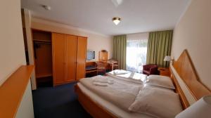 ein Hotelzimmer mit einem großen Bett und einem Schreibtisch in der Unterkunft ciao-aschau Haus zur Burg Apn21 Krämer in Aschau