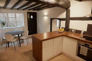 a kitchen with a counter and a table and chairs at Duck Cottage in the centre of Henley in Henley on Thames