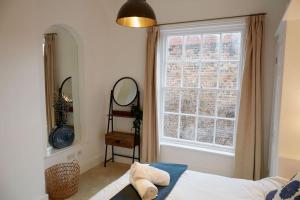 a bedroom with a bed and a window at Duck Cottage in the centre of Henley in Henley on Thames